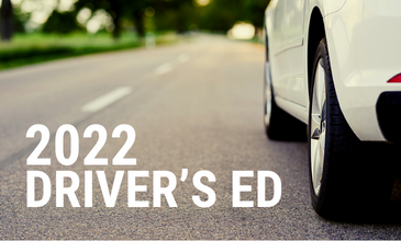 White car driving down two lane road with words 2022 Driver's Ed